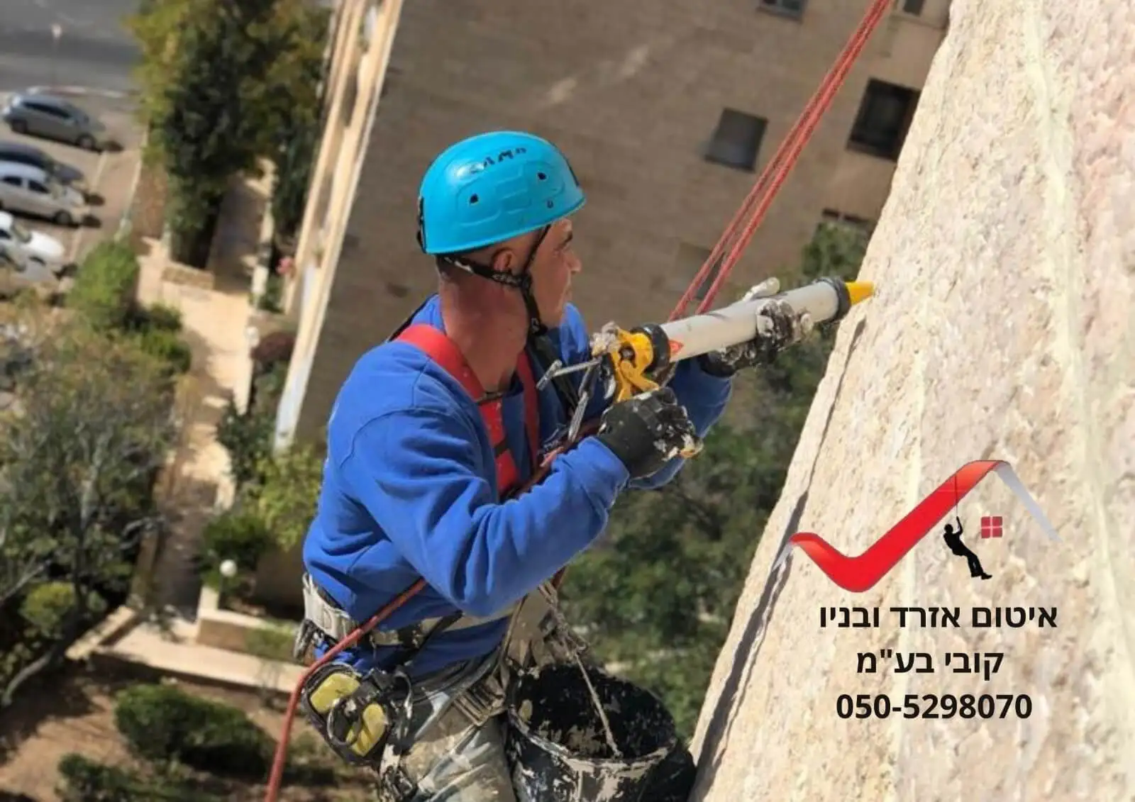 עובד של איטום אזרד ובניו תלוי בסנפלינג ואוטם תפר בקיר אבן חיצוני של בניין בירושלים