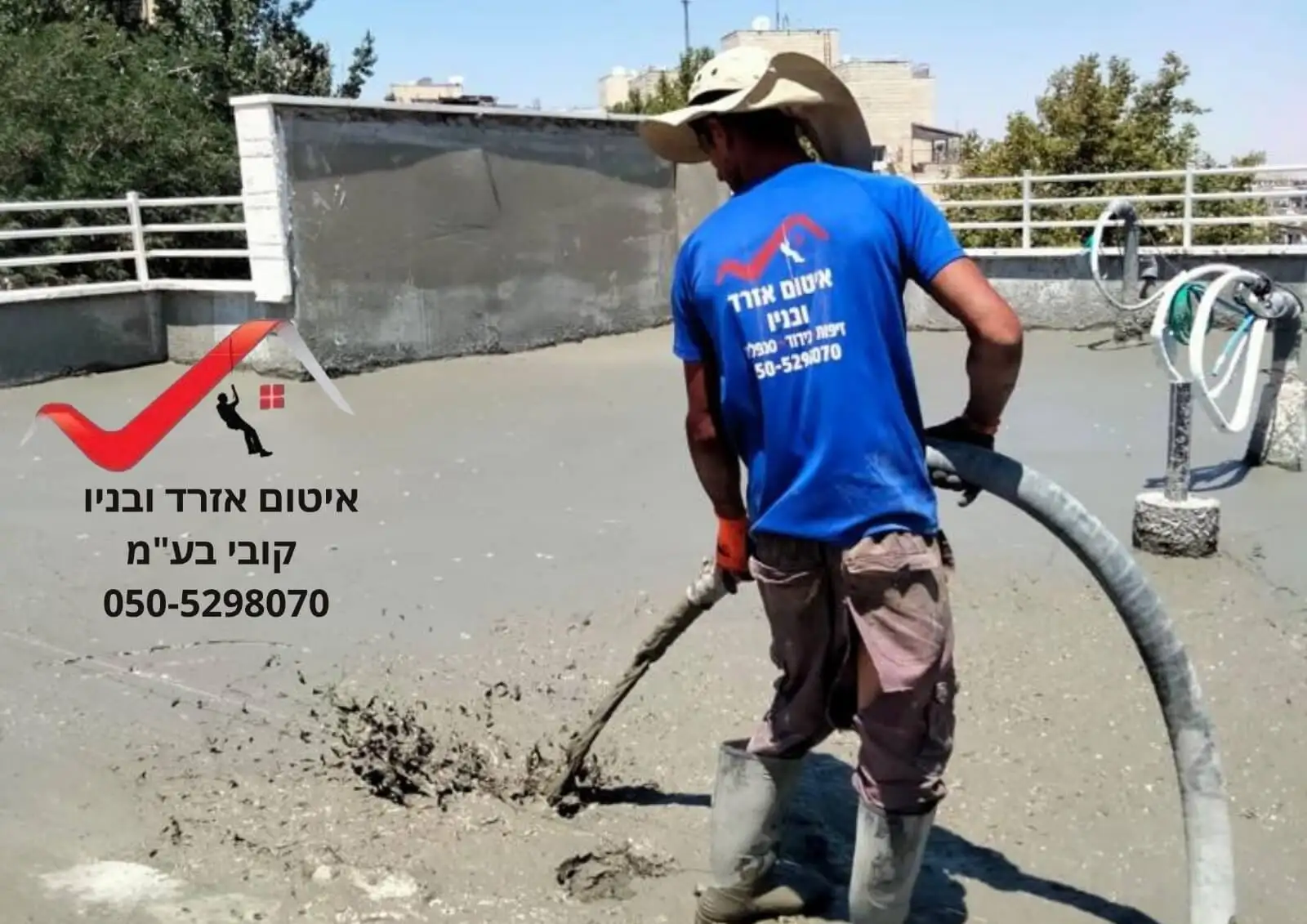 עובד מיישם שכבת איטום צמנטית על גג בטון שטוח בירושלים